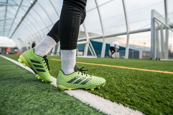 Artificial grass installation on sports field, using sand infill for playground construction