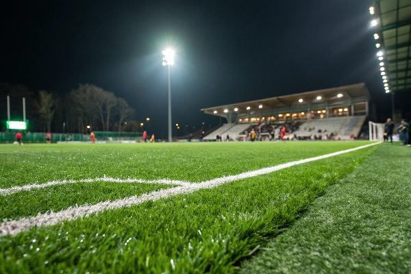 A beautiful artificial grass football field under bright lights