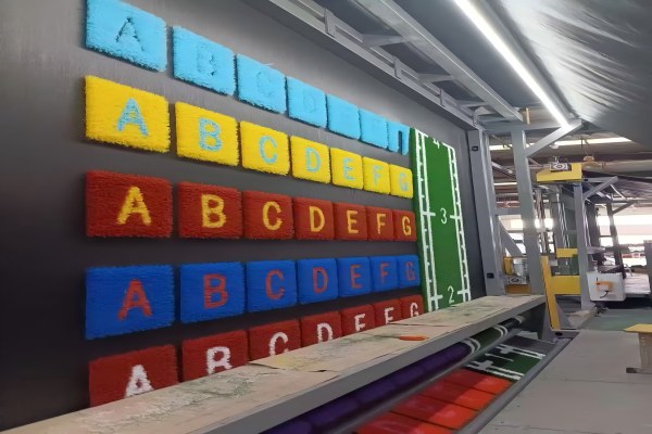 A photo of the QH Grass factory floor with machinery and turf rolls