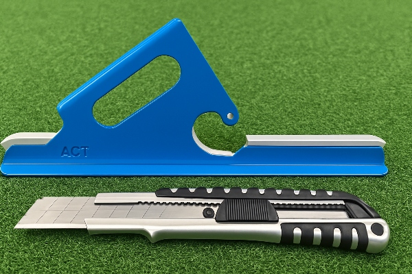 A close-up of a professional Grass Cutter with a hooked blade next to a standard utility knife