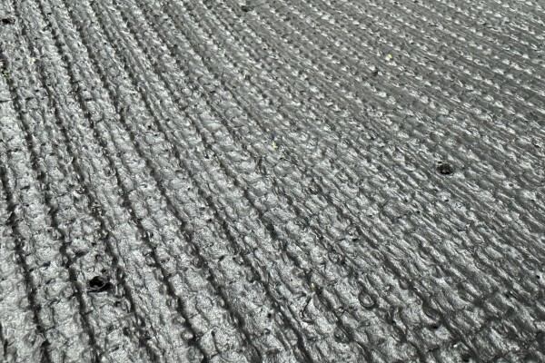 Water draining efficiently through artificial turf backing